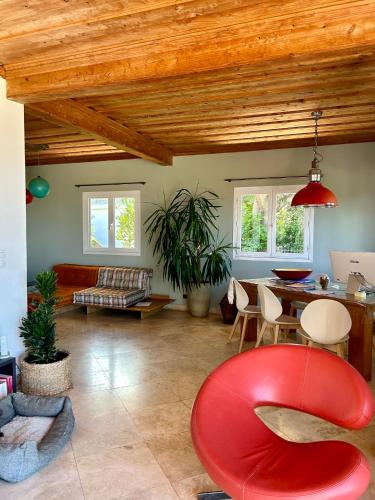 a living room with a red chair and a table at villa MILA in Ravine Sèche