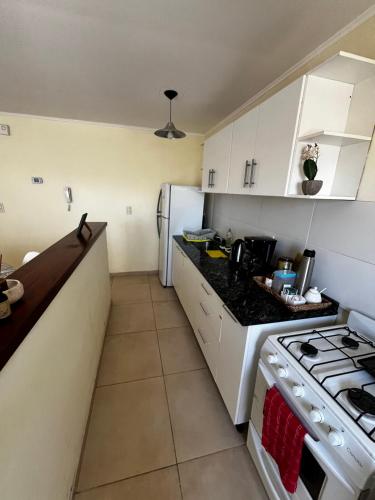 a kitchen with white cabinets and a stove top oven at Alojamiento El Remanso in Olavarría
