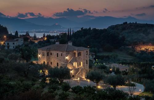 un gran edificio de piedra con luces encendidas por la noche en Klymeni Traditional Homes en Nafplio