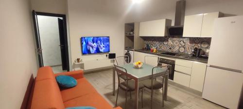 a living room with a couch and a table in a kitchen at Appartamento Fronte Mare a Falconara Marittima AN in Falconara Marittima