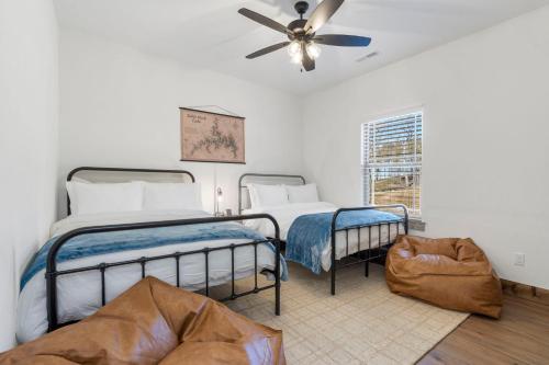 two beds in a room with a ceiling fan at Steps to Pond-Pvt Hot Tub-Community Indoor Pool-Near Thunder Ridge-Free Daily Tickets in Hollister