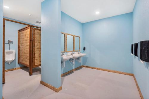 ein Badezimmer mit zwei Waschbecken und zwei Urinalen in der Unterkunft Firepit-Pvt Hot Tub-Cozy Retreat-Free Attraction Tickets-Cmty Indoor Pool in Hollister