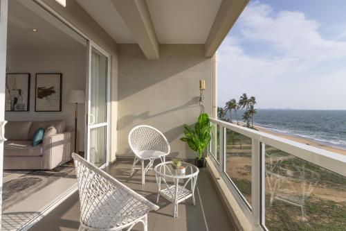 a balcony with chairs and a table and the ocean at Luxury Beachfront Stay - Sheki Sands in Wattala