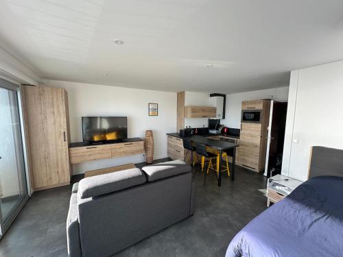 ラ・ボールにあるStudio face merのソファとキッチンのあるリビングルーム