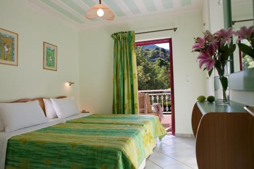 a bedroom with a bed and a sliding glass door at Exanthia Villas in Exanthia
