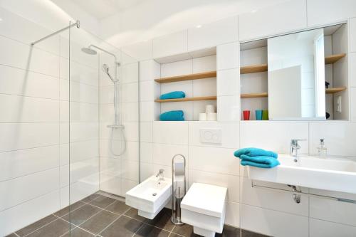 a white bathroom with a sink and a shower at Altstadtapartment Bel Etage in Heidelberg