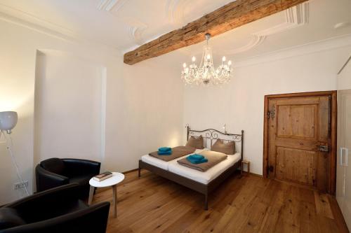 a bedroom with a bed and a chandelier at Altstadtapartment Bel Etage in Heidelberg