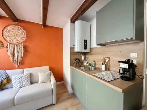 une cuisine avec un canapé à côté d'un évier dans l'établissement Studio lumineux centre Aix en Provence, à Aix-en-Provence