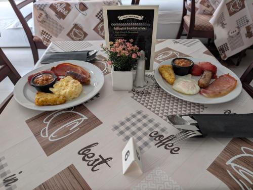 two plates of breakfast food on a table at Cecil Court Hotel in Bournemouth