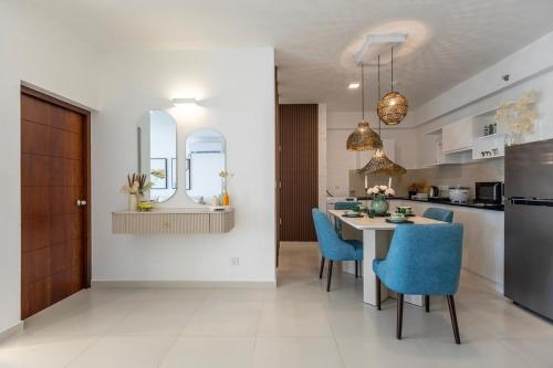 a kitchen and dining room with a table and blue chairs at Luxury Beachfront Stay - Sheki Sands in Wattala