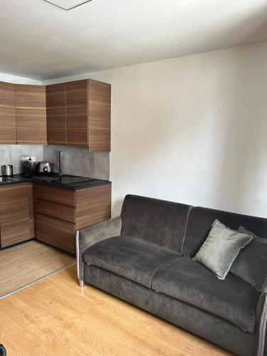 un salon avec un canapé et une cuisine dans l'établissement Studio Serre Chevalier 50 m des pistes GRAND PRE, à La Salle Les Alpes