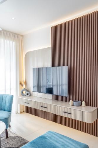 a living room with a television on a wooden wall at Luxury Beachfront Stay - Sheki Sands in Wattala