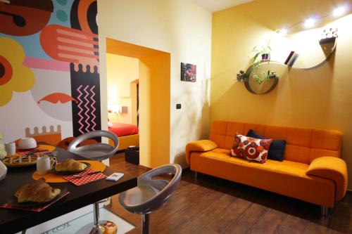 ein Wohnzimmer mit einem orangenen Sofa und einem Tisch in der Unterkunft La Casetta di Nonna Carmela in Bovino