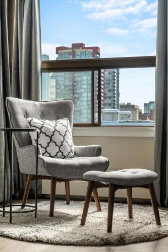 a chair and stool in a room with a window at Calgary Beltline - a stylish condo stay! in Calgary