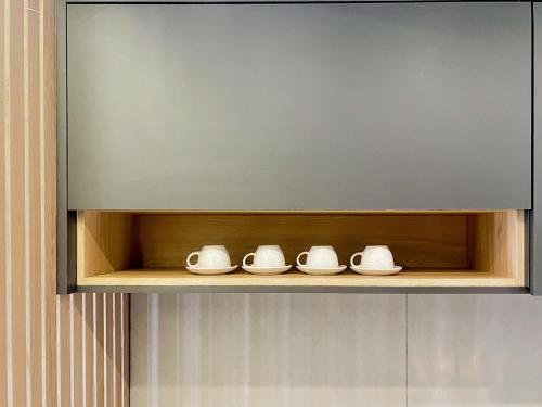 a shelf with four white dishes on it at Modern Studio Brooklin 230 meters from the subway in Sao Paulo