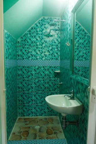 a blue tiled bathroom with a sink and a mirror at Hotel Calamari Baru in Playa Blanca