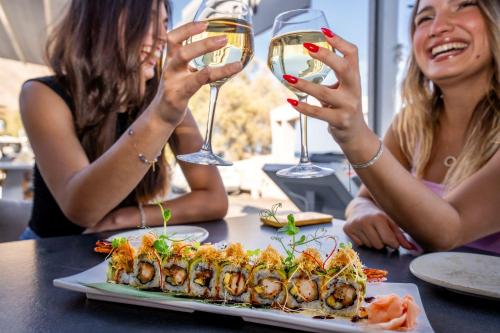 two women sitting at a table with glasses of wine at Zen Suites & Spa in Perissa
