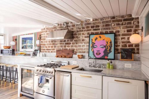 a kitchen with a brick wall and a counter top at The Courtyard at CasaZoe in Charleston