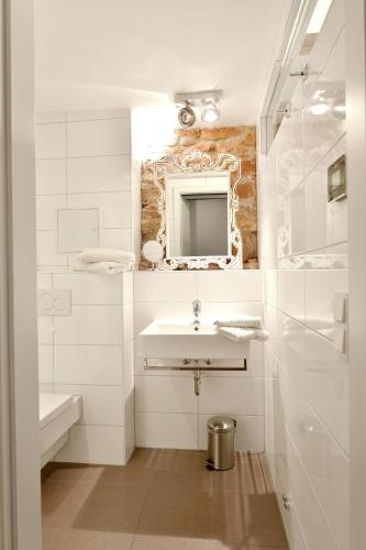 a white bathroom with a sink and a mirror at Altstadtapartment Remise in Heidelberg