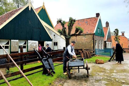 a man standing in front of a black building with a tool at Beach villa at the IJsselmeer 8p in Enkhuizen