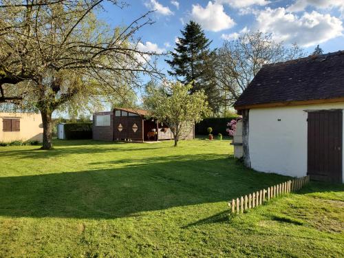 a yard with a house and a fence at Bungalow à la campagne in Senonches