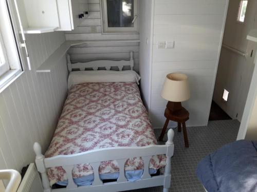 a small bedroom with a bed in a small room at Bungalow à la campagne in Senonches