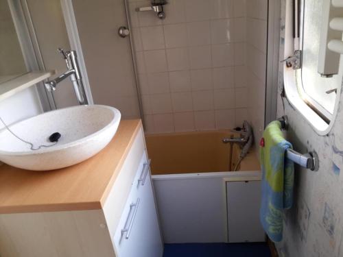 a bathroom with a sink and a bath tub at Bungalow à la campagne in Senonches