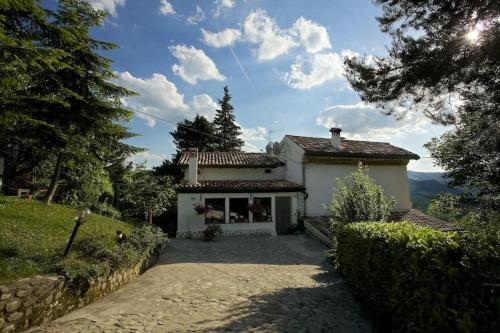 a small white house with a driveway in front of it at B&B Molino Del Gobbo in SantʼAgata Feltria