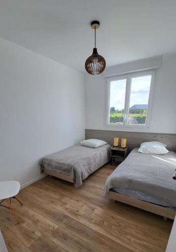 une chambre avec deux lits et une fenêtre dans l'établissement Maison le dauphin Kerlouan, à Kerlouan