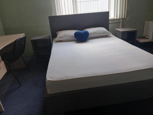 a bed with a blue bow on top of it at Mary&George in Chişinău