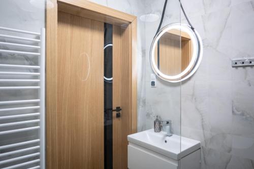 a bathroom with a toilet and a sink and a mirror at Zacisze Deluxe - Apartamenty in Krościenko