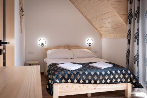 a bedroom with a bed with two towels on it at Zacisze Deluxe - Apartamenty in Krościenko
