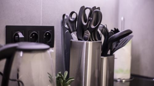 a group of scissors in a metal container on a counter at Apartament Antresola Przemyśl in Przemyśl