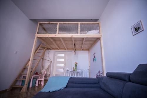 a living room with a couch and a loft bed at Apartament Antresola Przemyśl in Przemyśl
