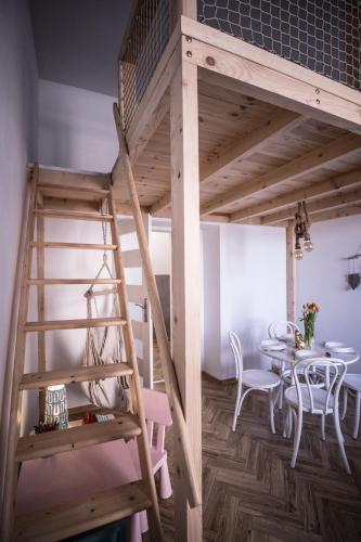 a loft bed with a table in a room at Apartament Antresola Przemyśl in Przemyśl