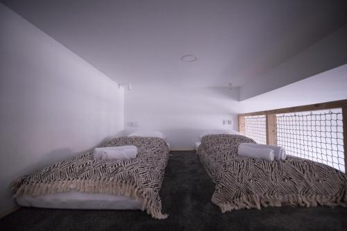 a bedroom with two beds and a window at Apartament Antresola Przemyśl in Przemyśl
