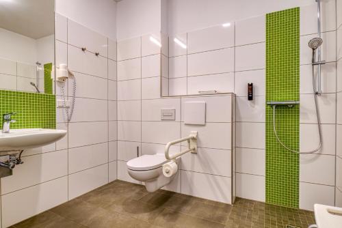 un baño con inodoro y lavabo en Nicetostay Aparthotel, en Bremen