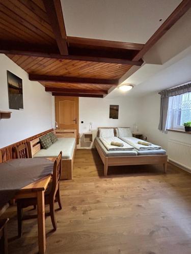 a large room with two beds and a table at Pension Hones in Horská Kvilda