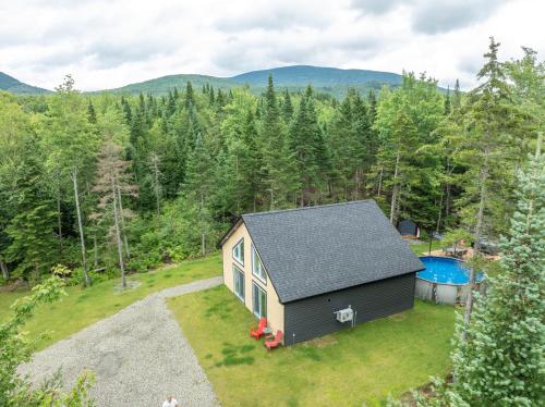 an aerial view of a tiny house with a swimming pool at Chalet Escapade, Spa, Piscine in La Patrie