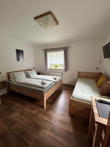 a bedroom with two beds and a window at Pension Hones in Horská Kvilda