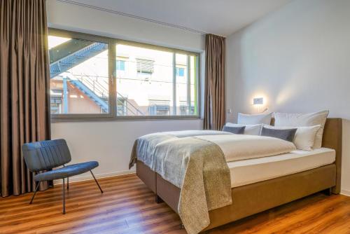Un dormitorio con una cama grande y una ventana. en Nicetostay Aparthotel, en Bremen