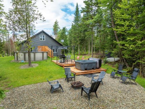 a backyard with a picnic table and chairs at Chalet Escapade, Spa, Piscine in La Patrie