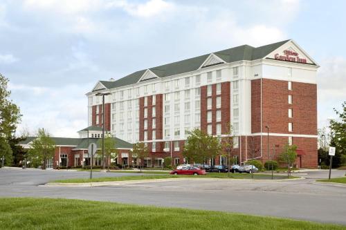 a building with a red car parked in front of it at Hilton Garden Inn Hoffman Estates in Hoffman Estates