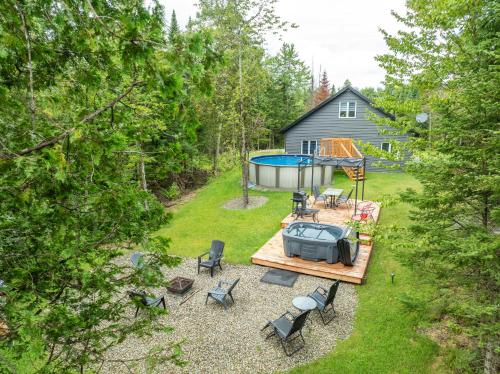 an aerial view of a backyard with a pool and chairs at Chalet Escapade, Spa, Piscine in La Patrie