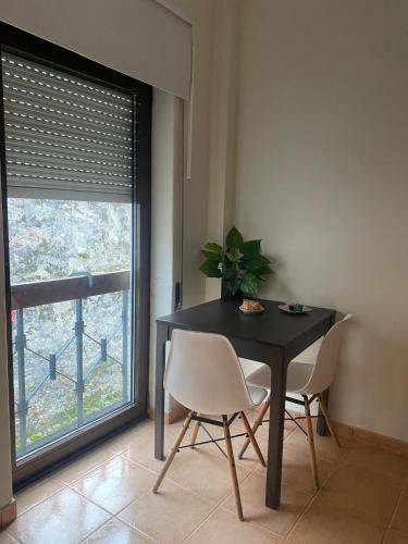 a dining room with a table and chairs and a window at Cici Guesthouse in Caminha