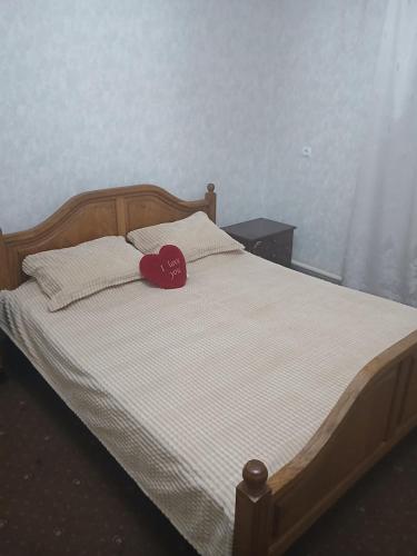 a bed with a red heart pillow on it at Mary&George in Chişinău