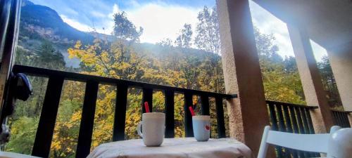 a balcony with a table with a view of the mountains at Carlina Canfranc in Canfranc-Estación