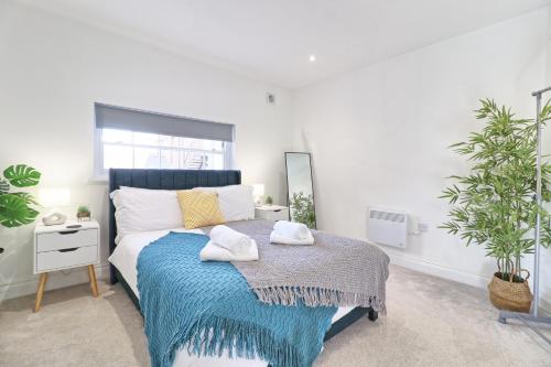 a bedroom with a bed with towels on it at Chelmsford City Centre Modern Duplex With Parking, Wi-Fi & Netflix in Chelmsford