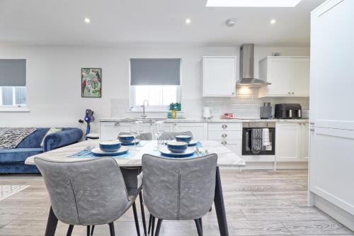 a kitchen and living room with a table and chairs at Chelmsford City Centre Modern Duplex With Parking, Wi-Fi & Netflix in Chelmsford
