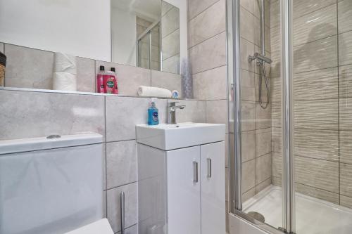 a bathroom with a shower and a sink and a toilet at Chelmsford City Centre Modern Duplex With Parking, Wi-Fi & Netflix in Chelmsford